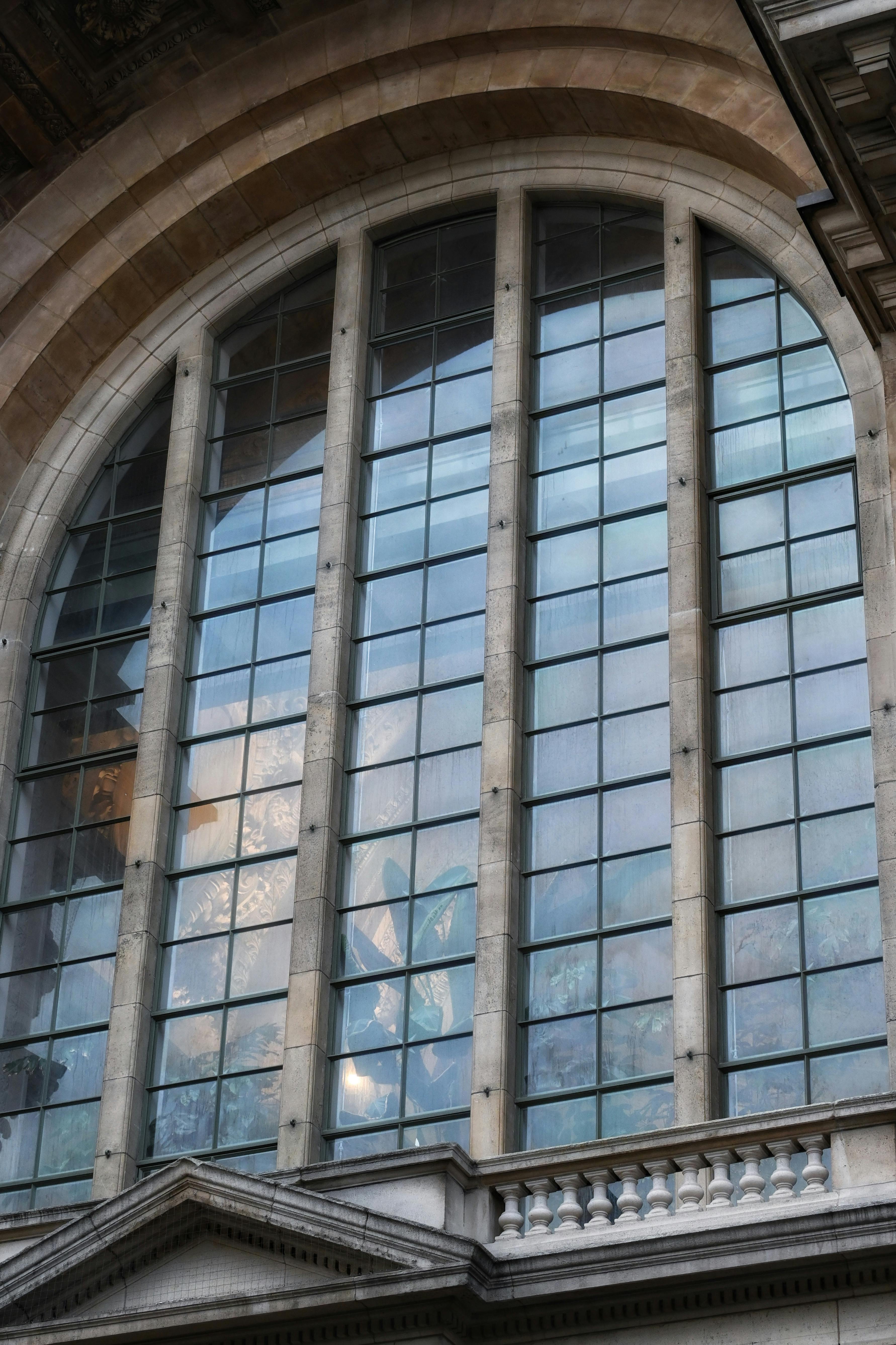 ฟรี หน้าต่างโค้งอันโดดเด่นของอาคารเก่าแก่แห่งหนึ่งในกรุงบรัสเซลส์ ประเทศเบลเยียม แสดงให้เห็นถึงความสง่างามทางสถาปัตยกรรม คลังภาพถ่าย