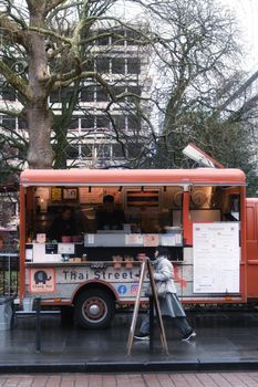 Explore a bustling Thai street food truck in a lively Brussels setting.