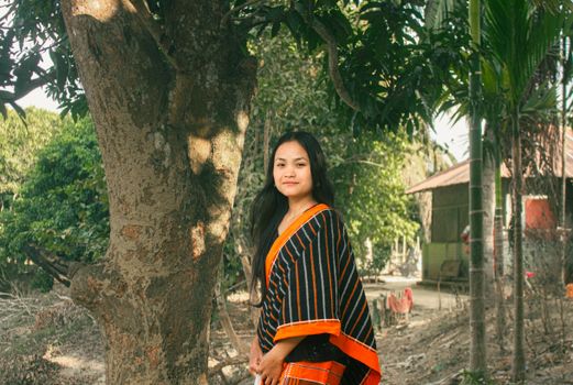 Young woman in vibrant traditional attire in rural Rangamati, Bangladesh.