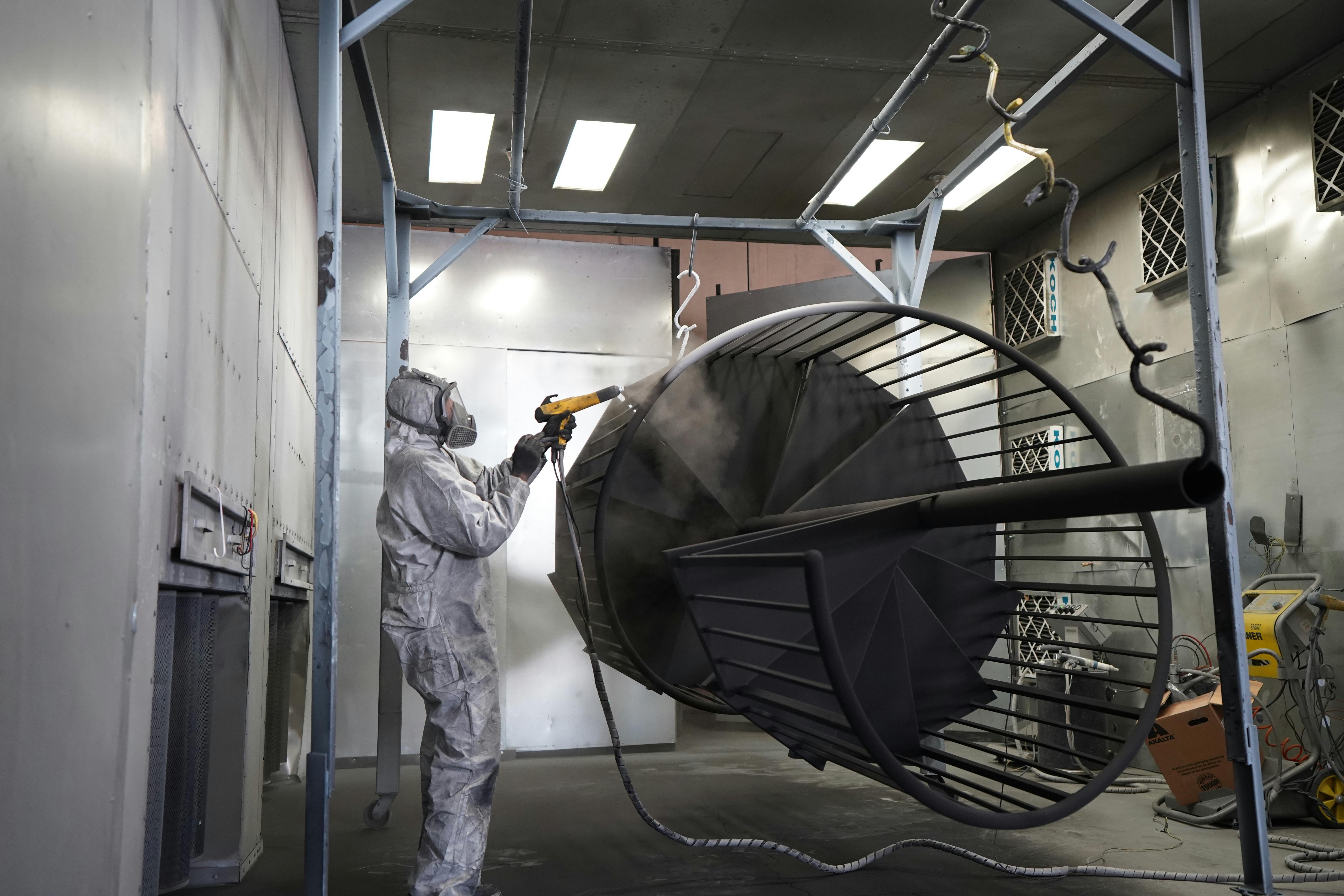 bezplatná Technik provádějící práškové lakování kovových konstrukcí v průmyslové dílně. Základová fotografie