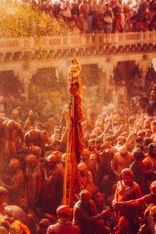 Free Energetic Holi festival scene with colorful powders and joyful crowd in India. Stock Photo