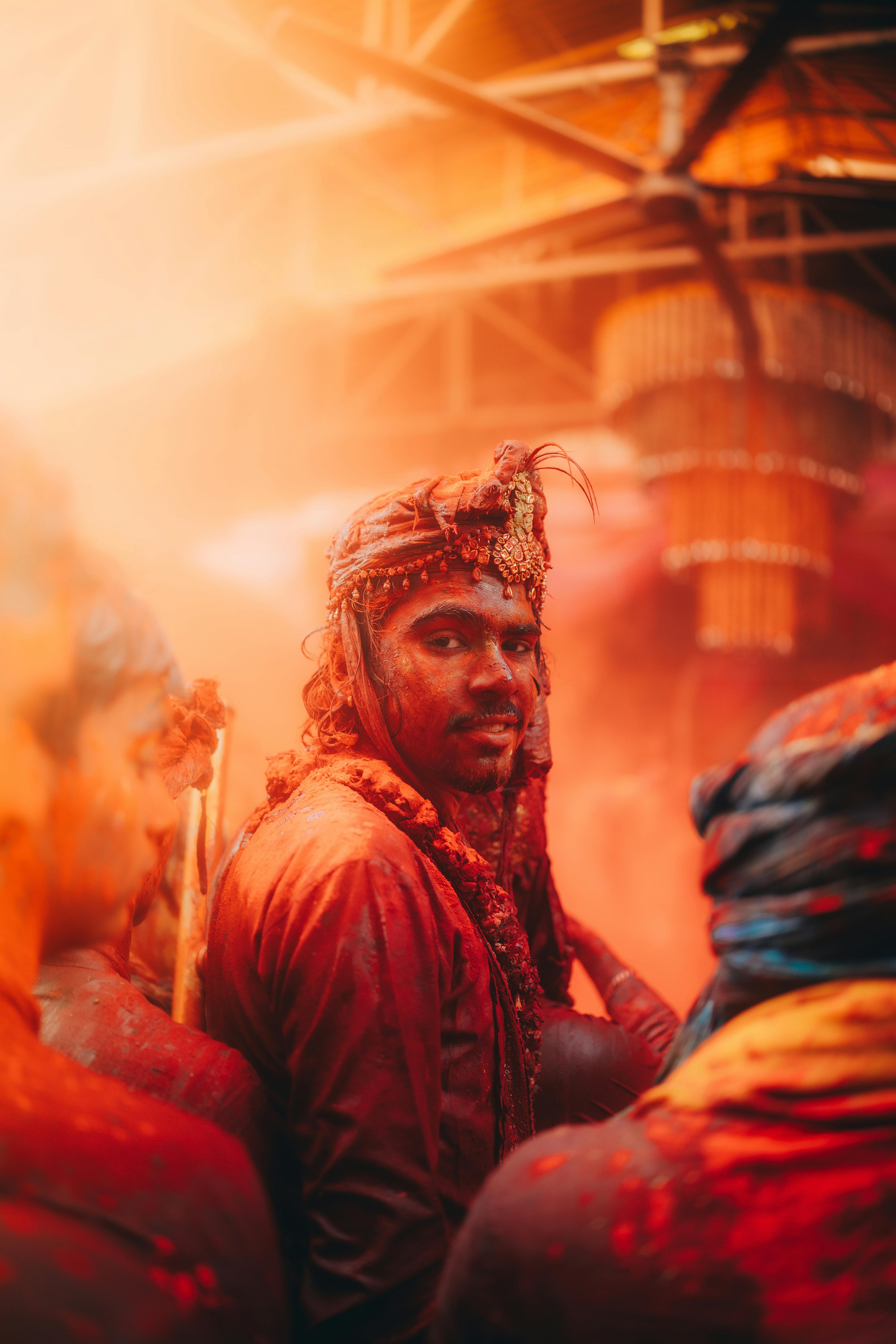 Gratis Immagine vibrante di un uomo che celebra la festa dell'Holi con polveri colorate in un ambiente chiuso. Foto a disposizione