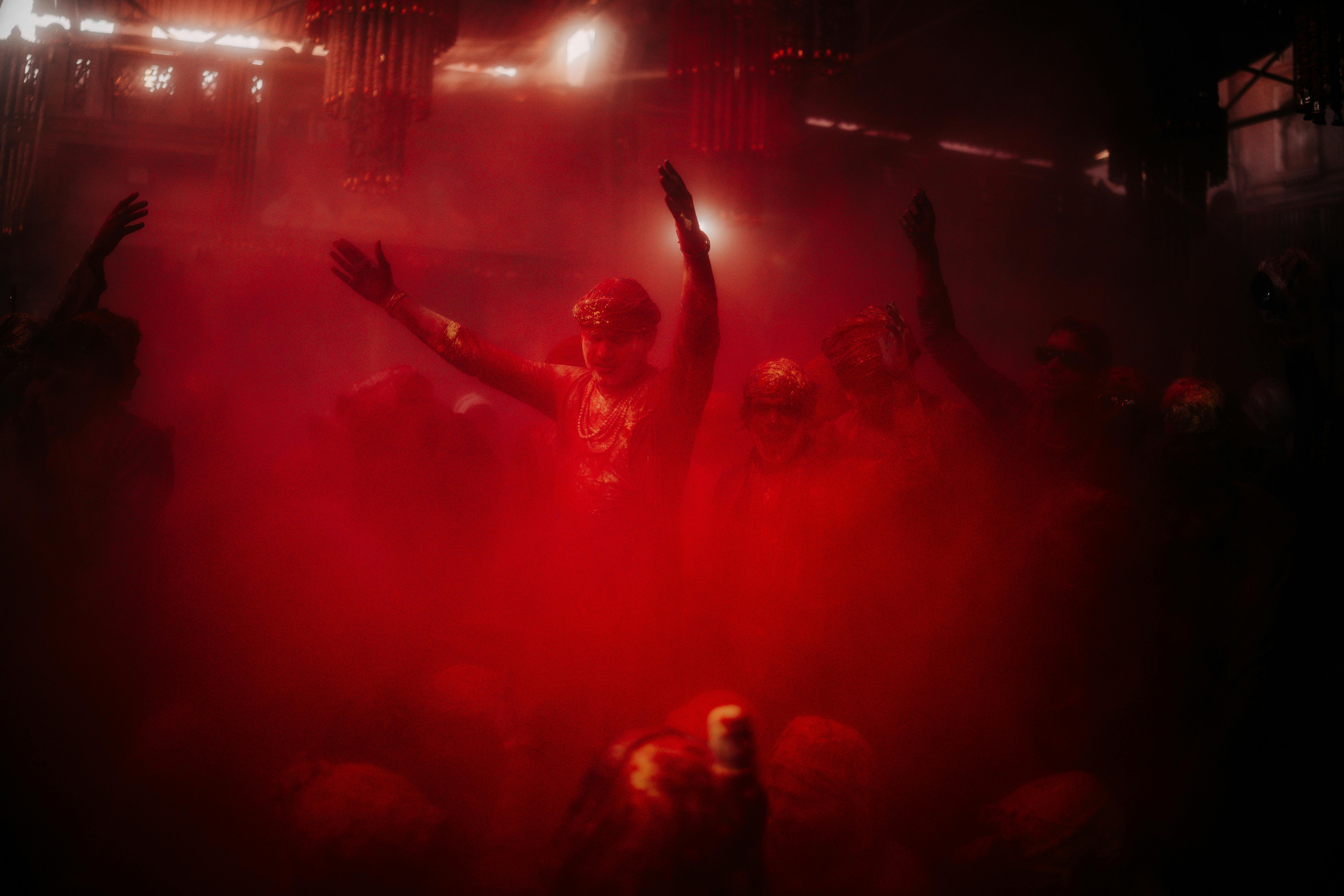 Ücretsiz Kırmızı tozla kaplı insanların kapalı alanda neşeyle kutlama yaptığı enerjik bir festival ortamı. Stok Fotoğraflar