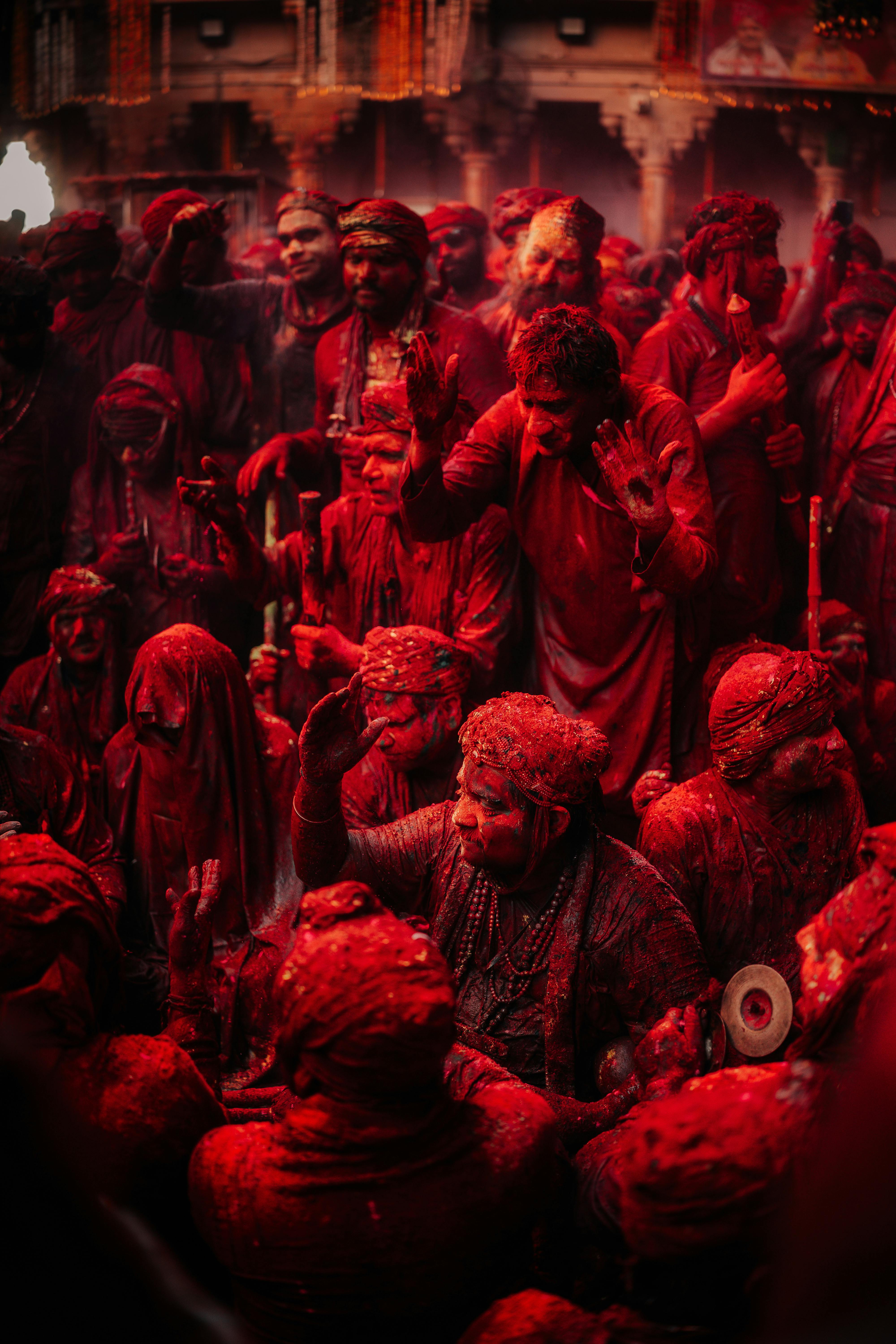 ฟรี กลุ่มคนสนุกสนานที่กำลังเฉลิมฉลองเทศกาลโฮลีอย่างมีสีสัน โดยทุกคนถูกปกคลุมไปด้วยผงสีแดง คลังภาพถ่าย