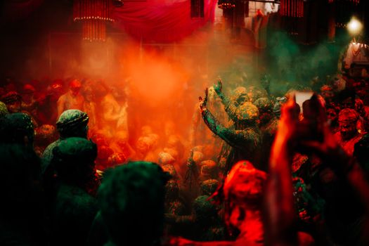 Colorful crowd enjoying Holi festival with vibrant clouds of powder.