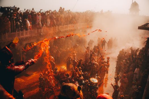 Crowds celebrate Holi with colorful powders creating a vibrant and lively atmosphere.