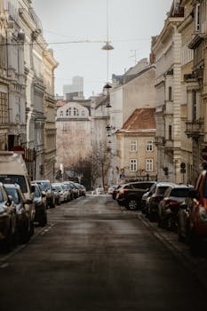 A captivating street view in Vienna showcasing classic architecture and parked cars under soft winter daylight.