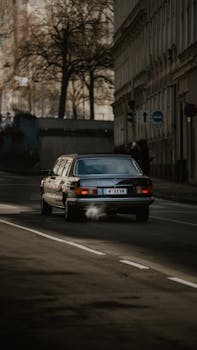 A vintage car driving through Vienna's streets with a nostalgic, urban feel.