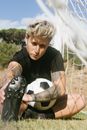 Person in Black Crew Neck T-shirt Holding Black Soccer Cleats