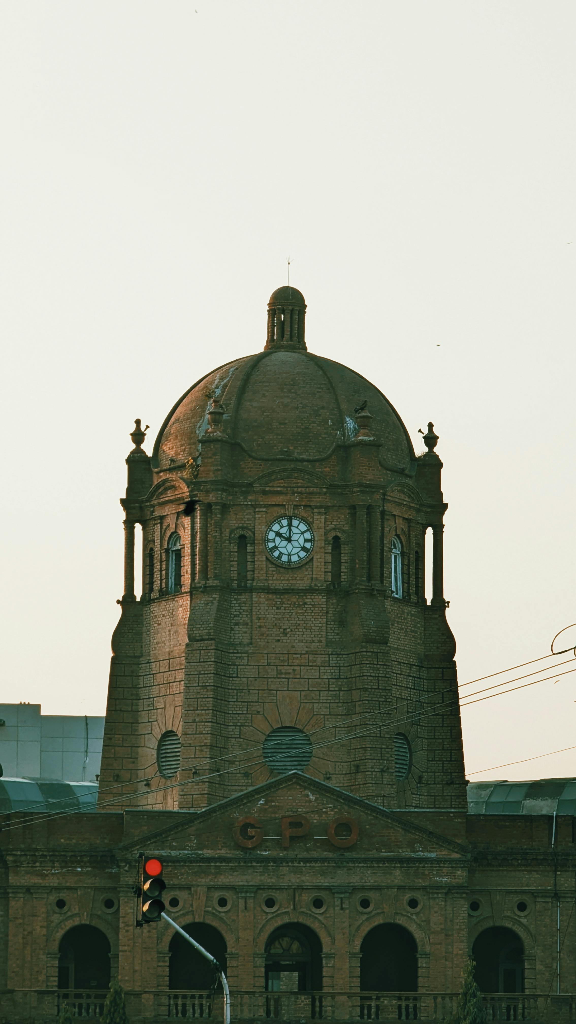 Gratis Et historisk klokketårn i mursten med en slående kuppel i skumringen og elegant arkitektur. Lagerfoto