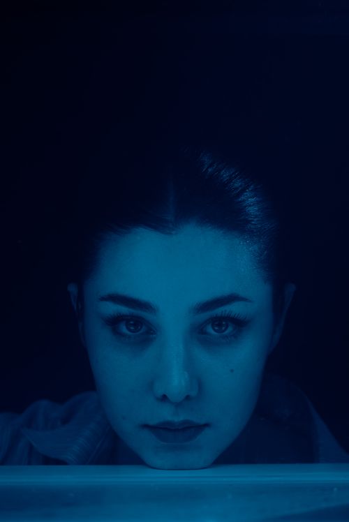 Free Serene portrait of a woman under dramatic blue lighting, reflecting deep emotion. Stock Photo