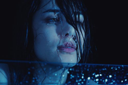 Free Atmospheric portrait of a wet Middle Eastern woman at night, conveying emotion. Stock Photo