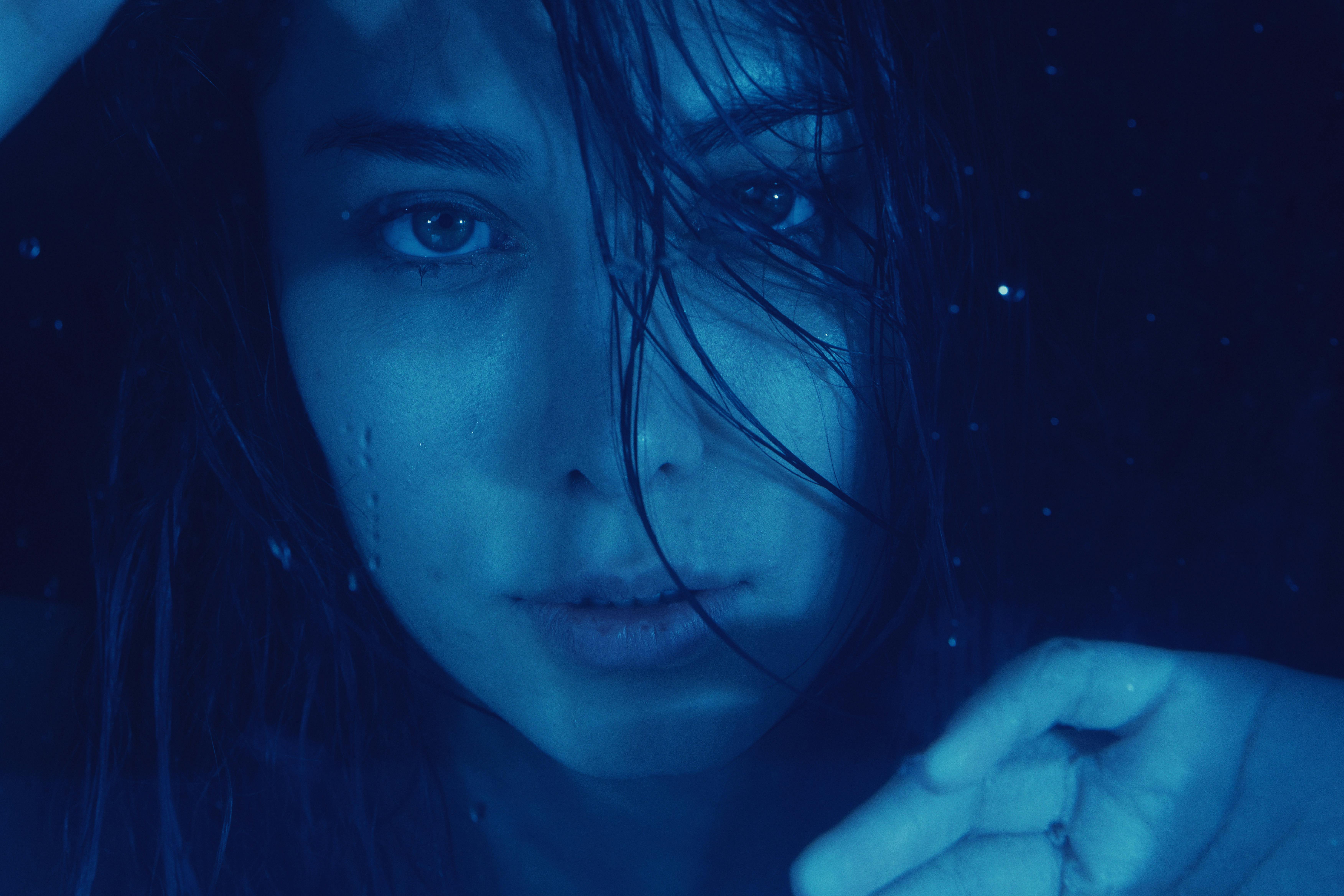 bezplatná Umělecký modře tónovaný portrét ženy vyjadřující emoce pod vodou. Základová fotografie