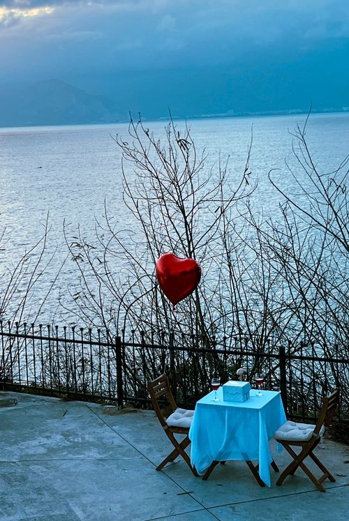 Free A romantic dinner setup by the lake with a heart-shaped balloon, perfect for Valentine's Day. Stock Photo