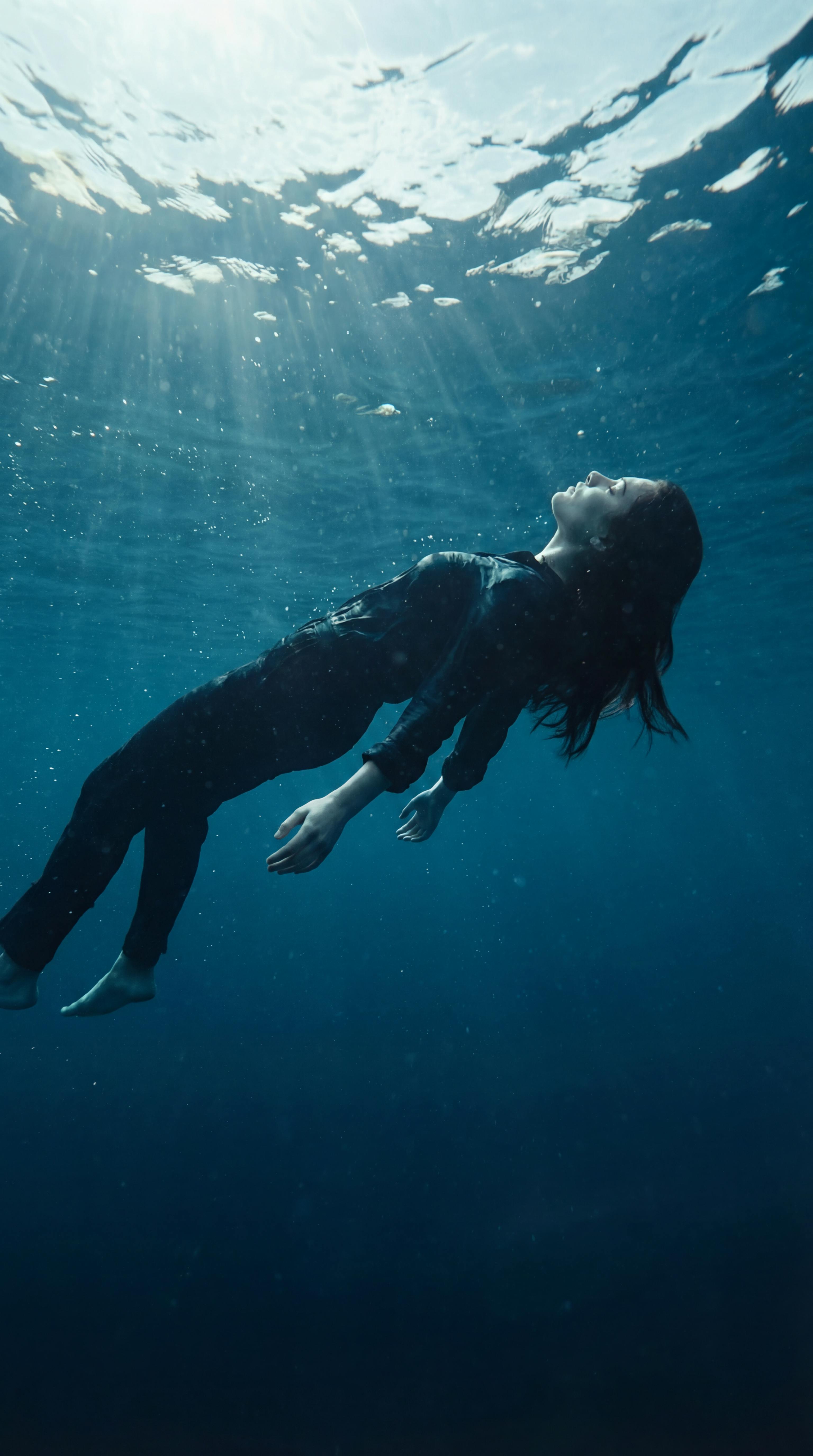 bezplatná Klidný podvodní portrét ženy, která se ladně vznáší v tyrkysovém moři. Základová fotografie