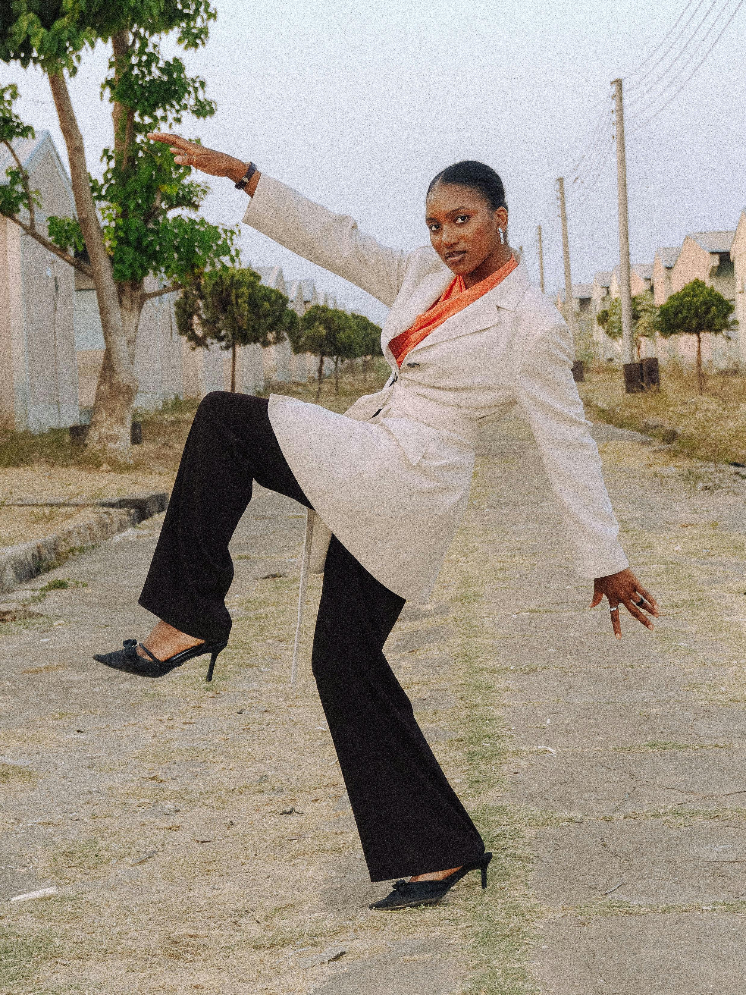 Gratis Una donna elegante di Abuja posa con sicurezza in un abito formale, mostrando uno stile di moda contemporaneo. Foto a disposizione