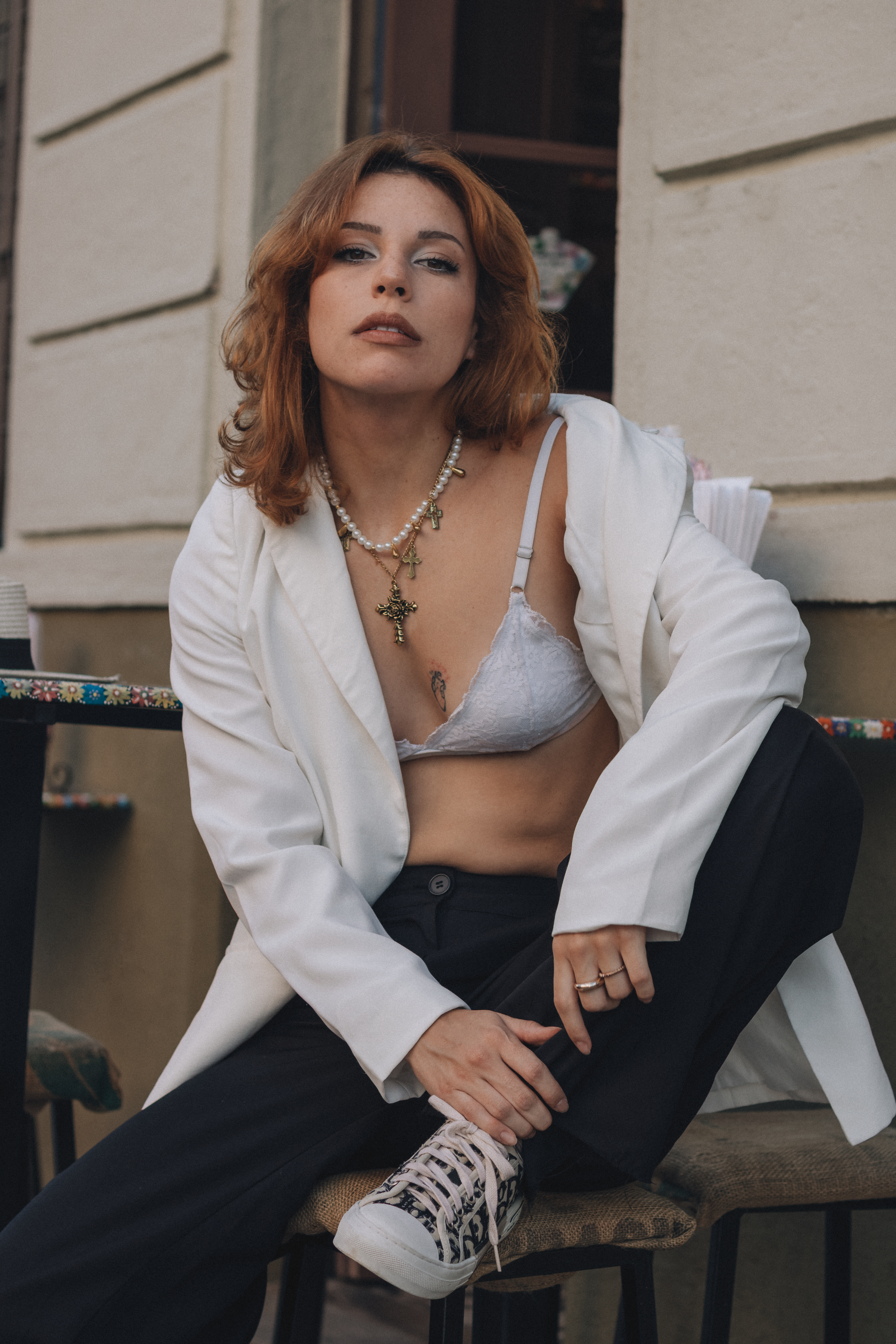 Chic urban fashion portrait featuring a stylish woman in a white blazer with casual elegance.