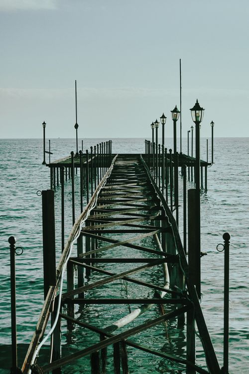 Free A rustic pier stretching into the calm ocean, offering a serene and nostalgic view. Stock Photo
