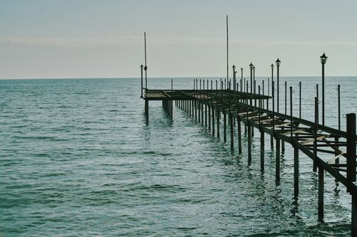 Free A tranquil view of a wooden pier extending into the calm ocean, creating a peaceful atmosphere. Stock Photo