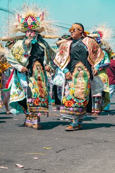 Colorful festival participants in traditional attire with religious iconography captured in vibrant daylight.