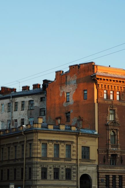 Old European buildings with rich architectural details illuminated by the warm glow of sunset.