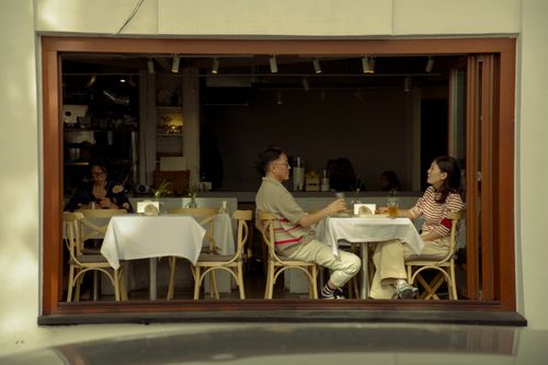 Free Two adults engaged in conversation at a cozy cafe. Warm and inviting. Stock Photo