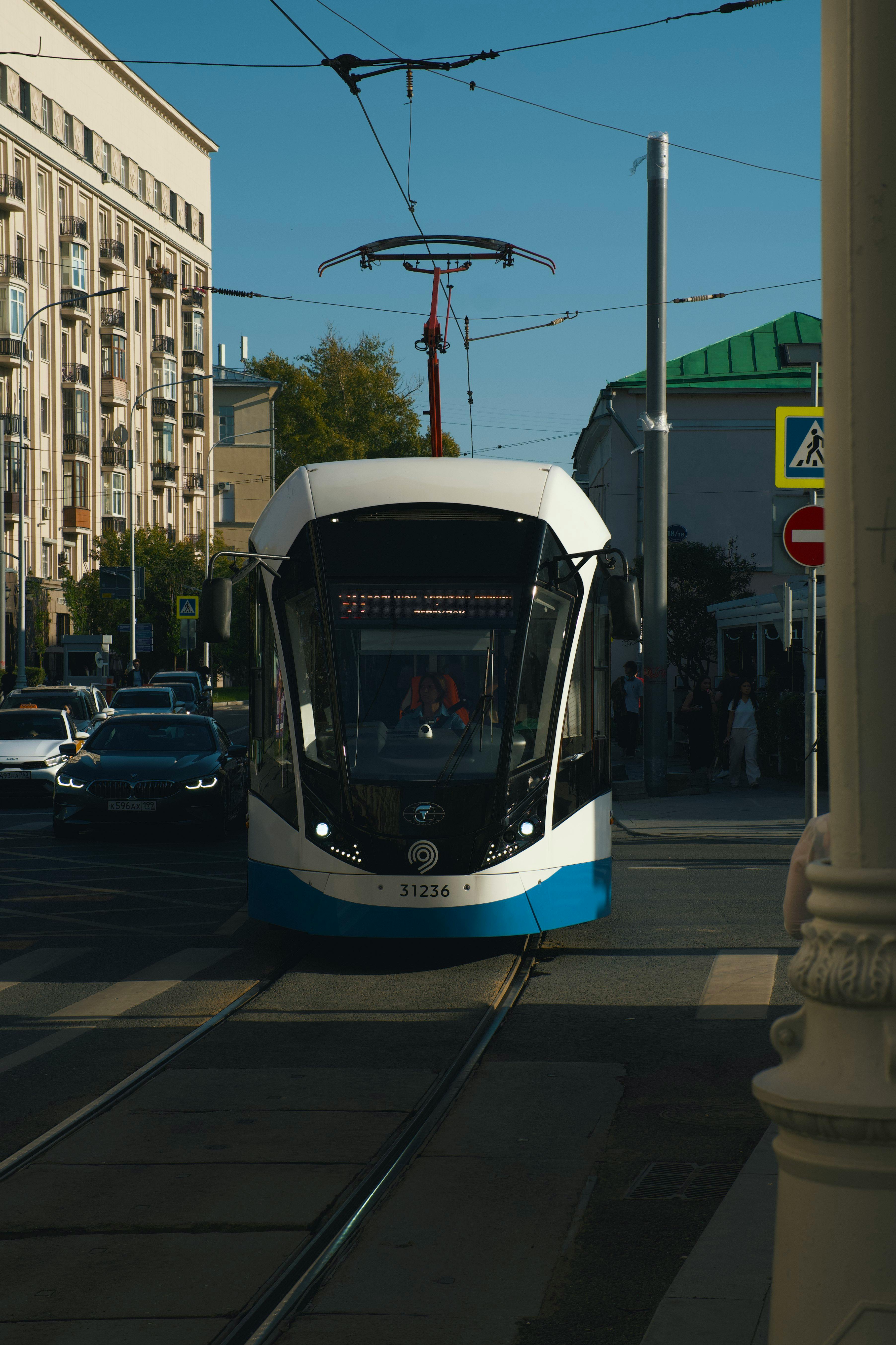 ฟรี รถรางสมัยใหม่แล่นไปตามถนนในเมืองในวันที่แดดจ้า บันทึกภาพชีวิตและการคมนาคมในเมืองไว้ได้ คลังภาพถ่าย