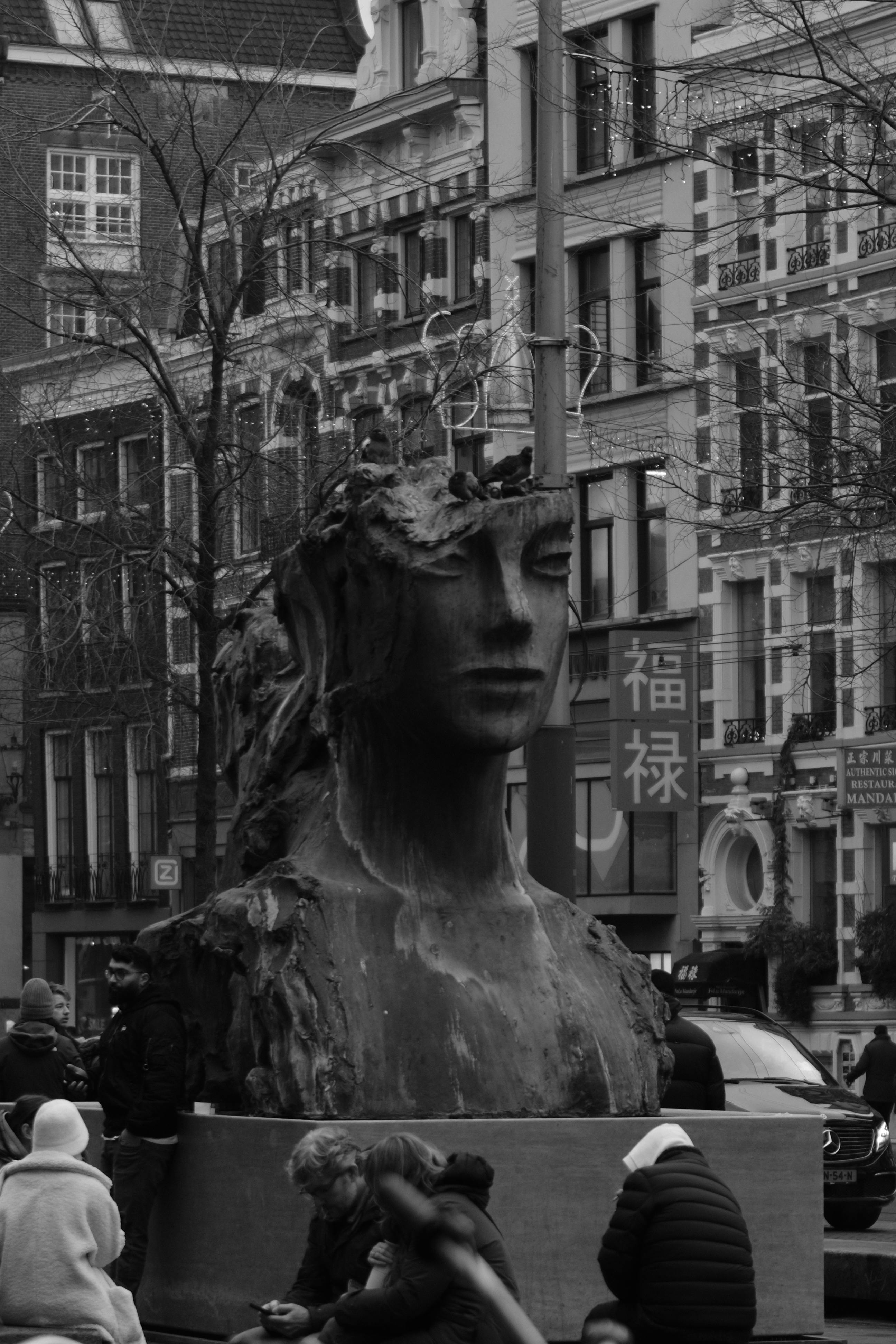 Gratis Foto in bianco e nero di una grande scultura circondata da persone in una strada di Amsterdam. Foto a disposizione