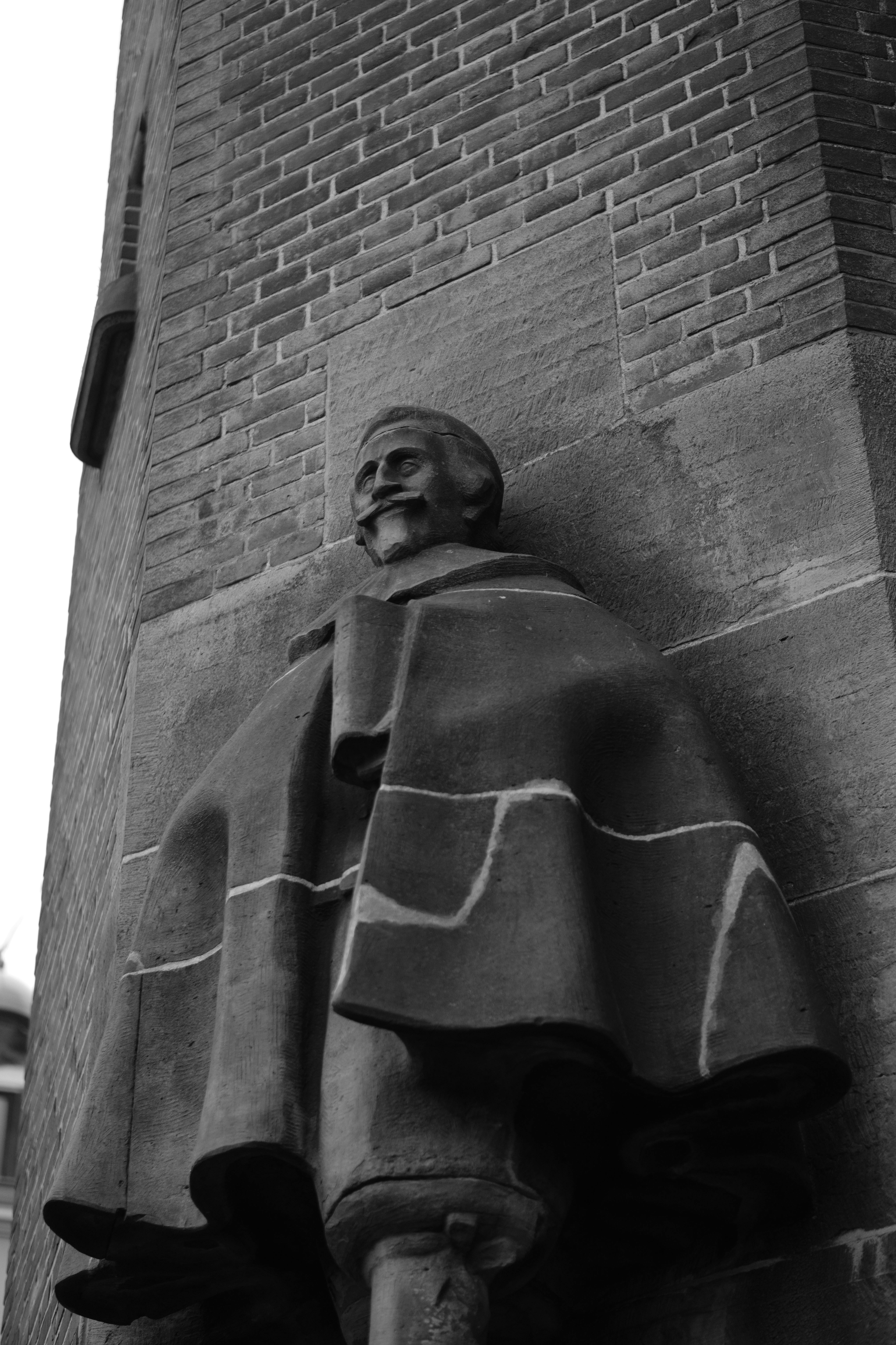 Free Monochrome image of a historical statue on a brick building in Amsterdam. Stock Photo