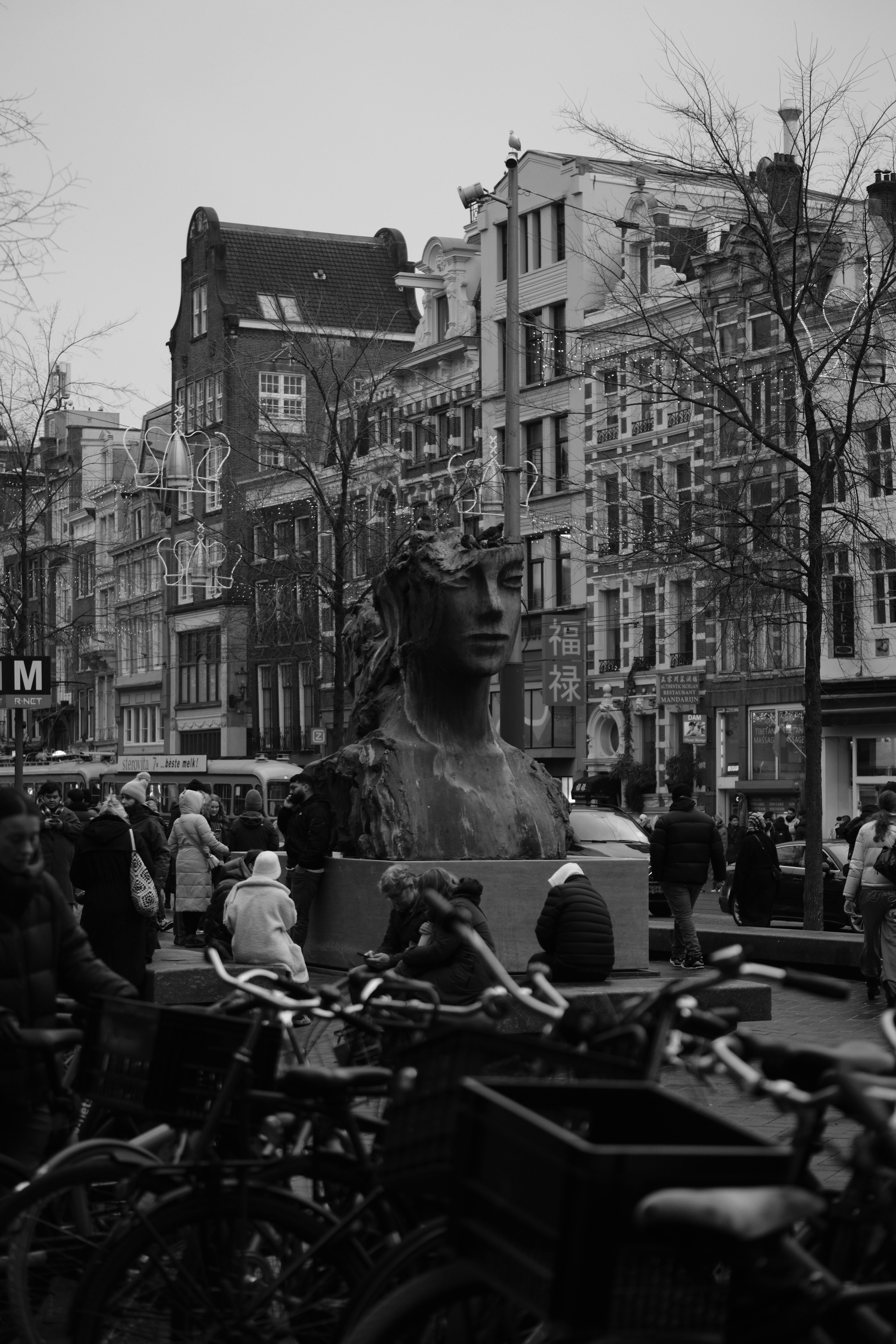 Ücretsiz Amsterdam'da dikkat çekici bir heykel ve tarihi binaların yer aldığı siyah beyaz bir sokak sahnesi. Stok Fotoğraflar