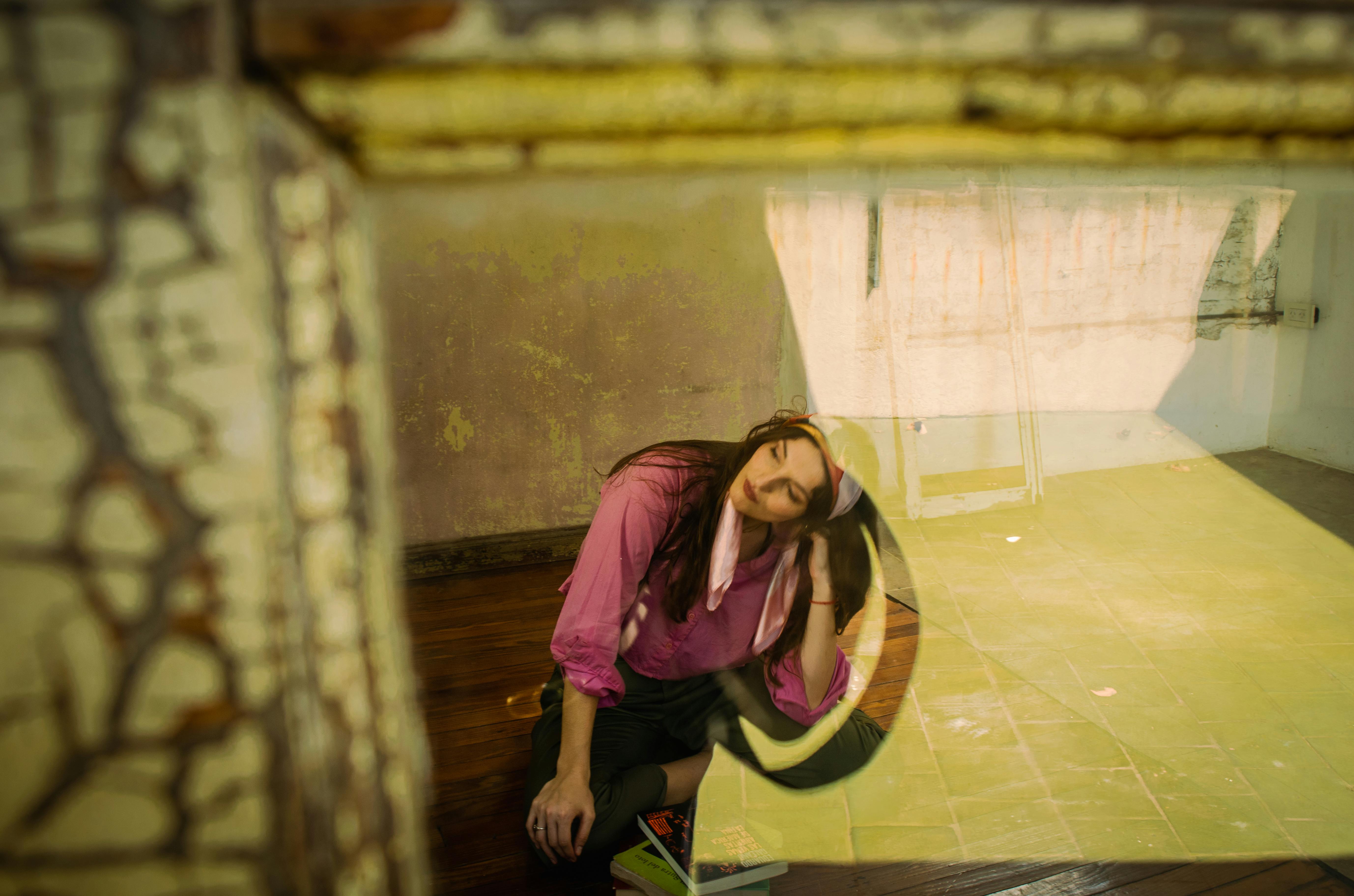 Gratis Una foto artistica e sognante di una donna con un top rosa, immortalata attraverso superfici riflettenti in un ambiente interno. Foto a disposizione