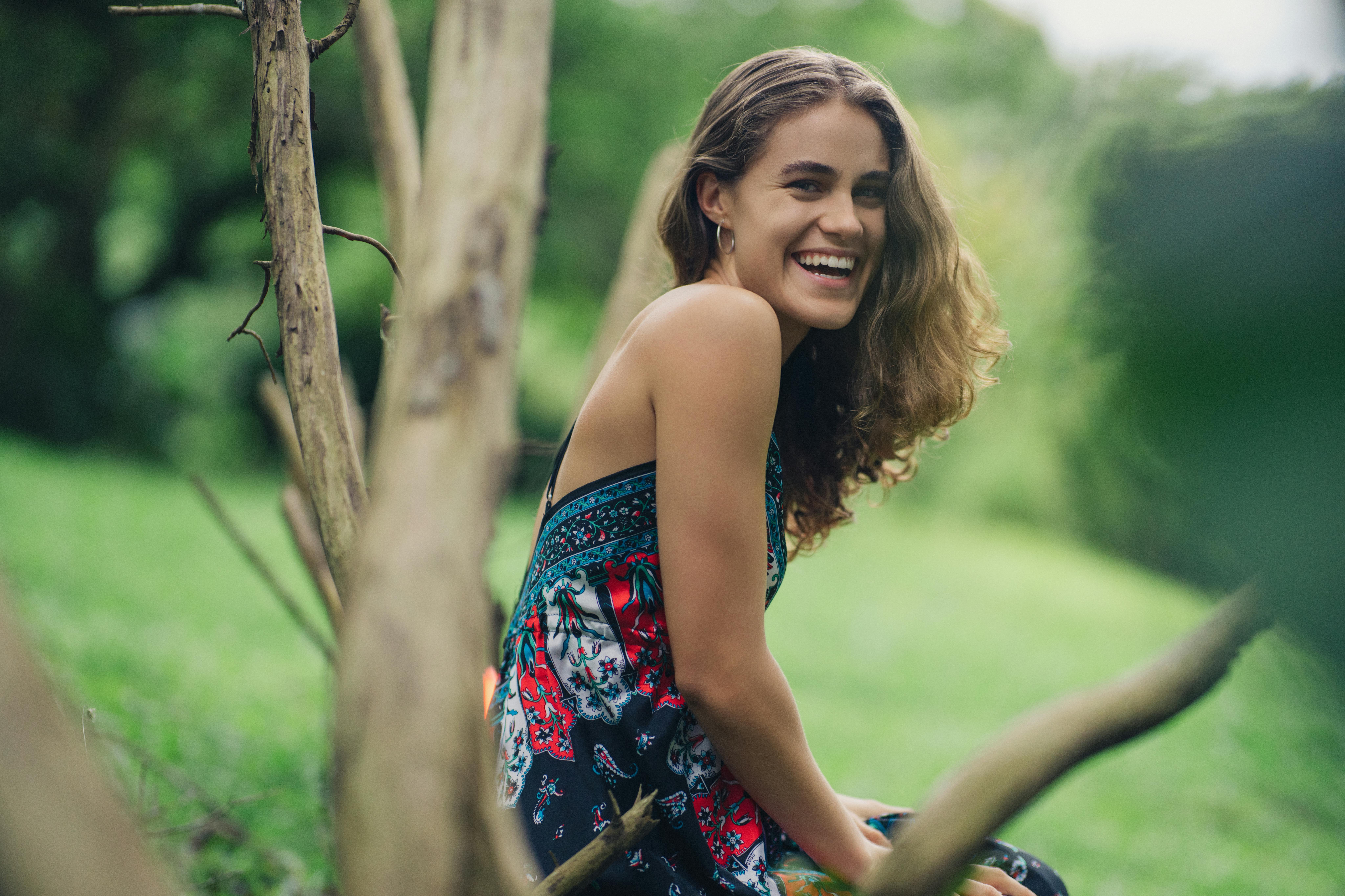 Gratis Donna sorridente con un abito dai colori vivaci si gode una giornata di sole a Varablanca, Costa Rica. Foto a disposizione