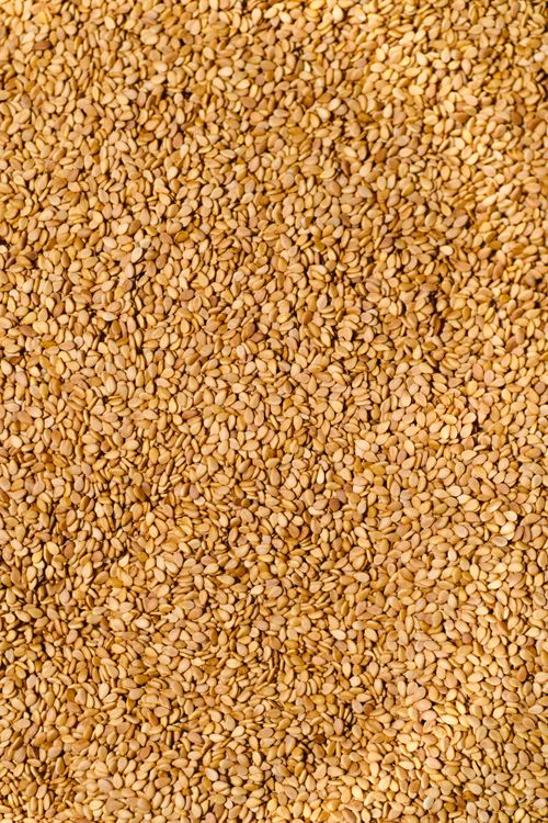Free Close-up of golden sesame seeds, creating a textured and natural background. Stock Photo