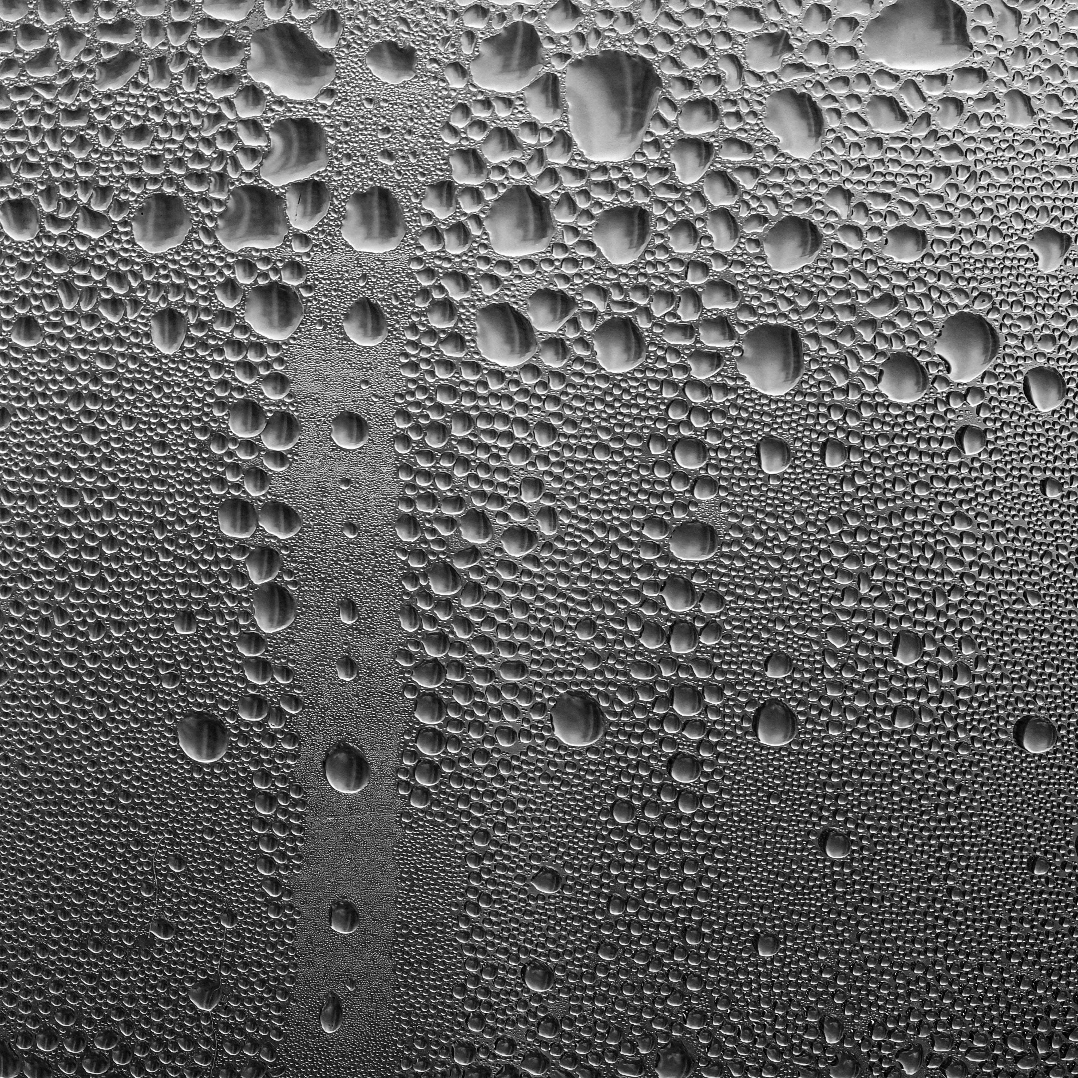 ฟรี ภาพระยะใกล้ของหยดน้ำที่เกาะอยู่บนกระจกหน้าต่าง แสดงให้เห็นถึงพื้นผิวและรายละเอียดต่างๆ คลังภาพถ่าย