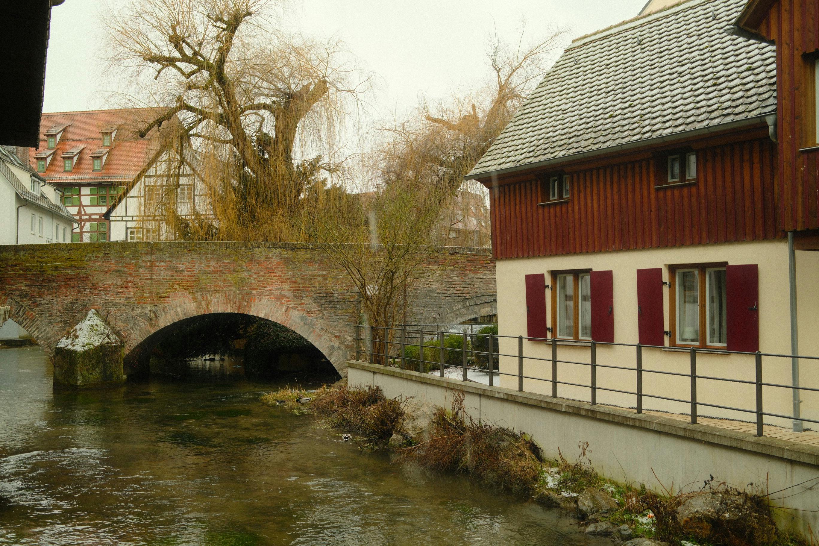 ฟรี ภาพทิวทัศน์ฤดูหนาวอันงดงามของสะพานเก่าแก่และอาคารต่างๆ ริมแม่น้ำในเมืองอูล์ม ประเทศเยอรมนี คลังภาพถ่าย