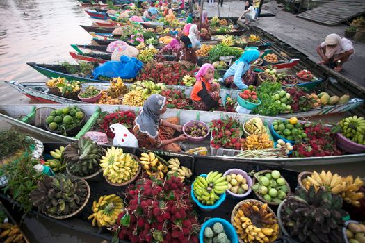 Colorful floating market scene with vendors in boats selling diverse fruits and vegetables.