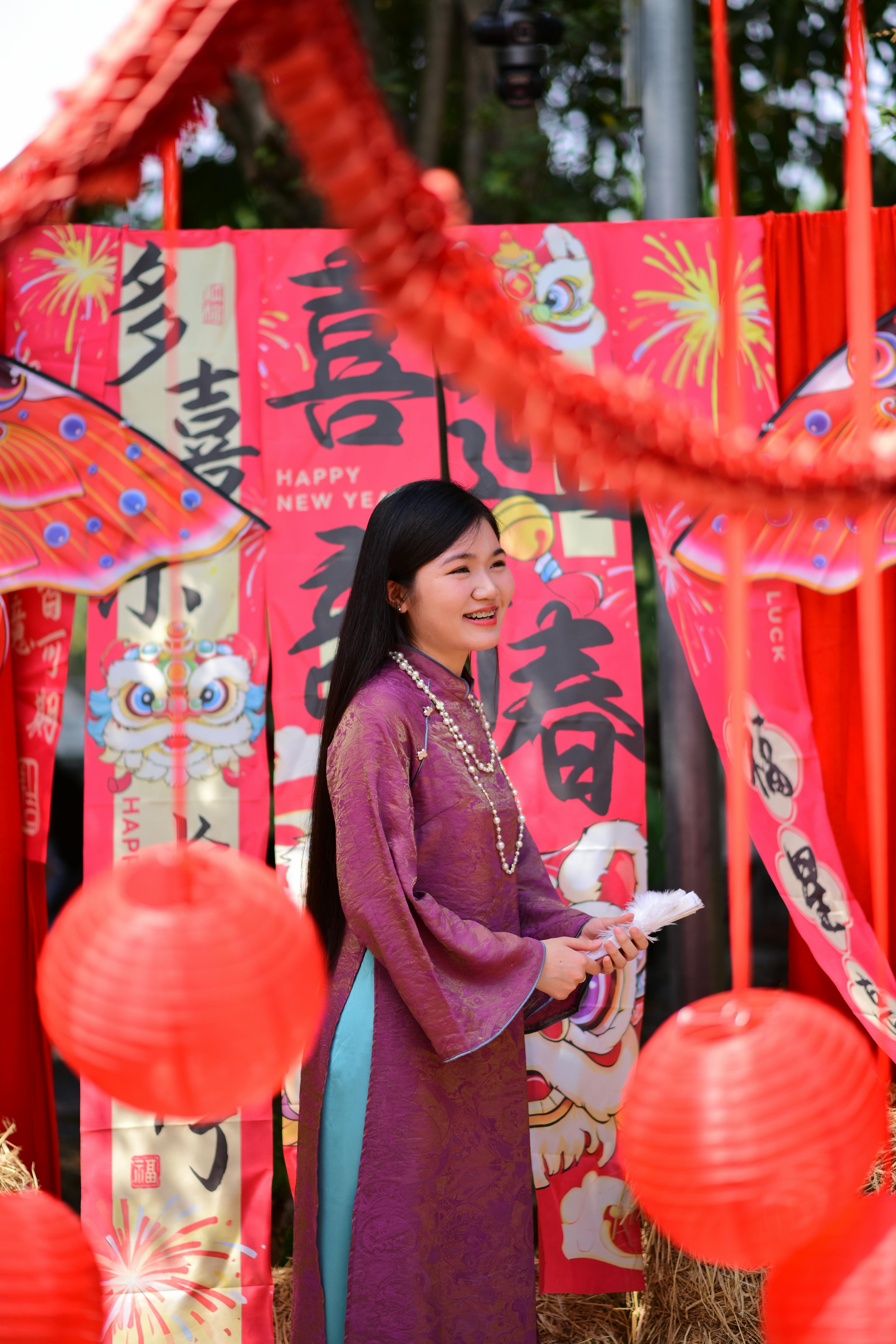 ฟรี หญิงวัยผู้ใหญ่ในชุดเทศกาลกำลังสนุกสนานกับการเฉลิมฉลองตรุษจีนที่ประดับประดาด้วยของตกแต่ง คลังภาพถ่าย