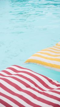 Vibrant striped pool floats on refreshing clear water, perfect for summer relaxation.