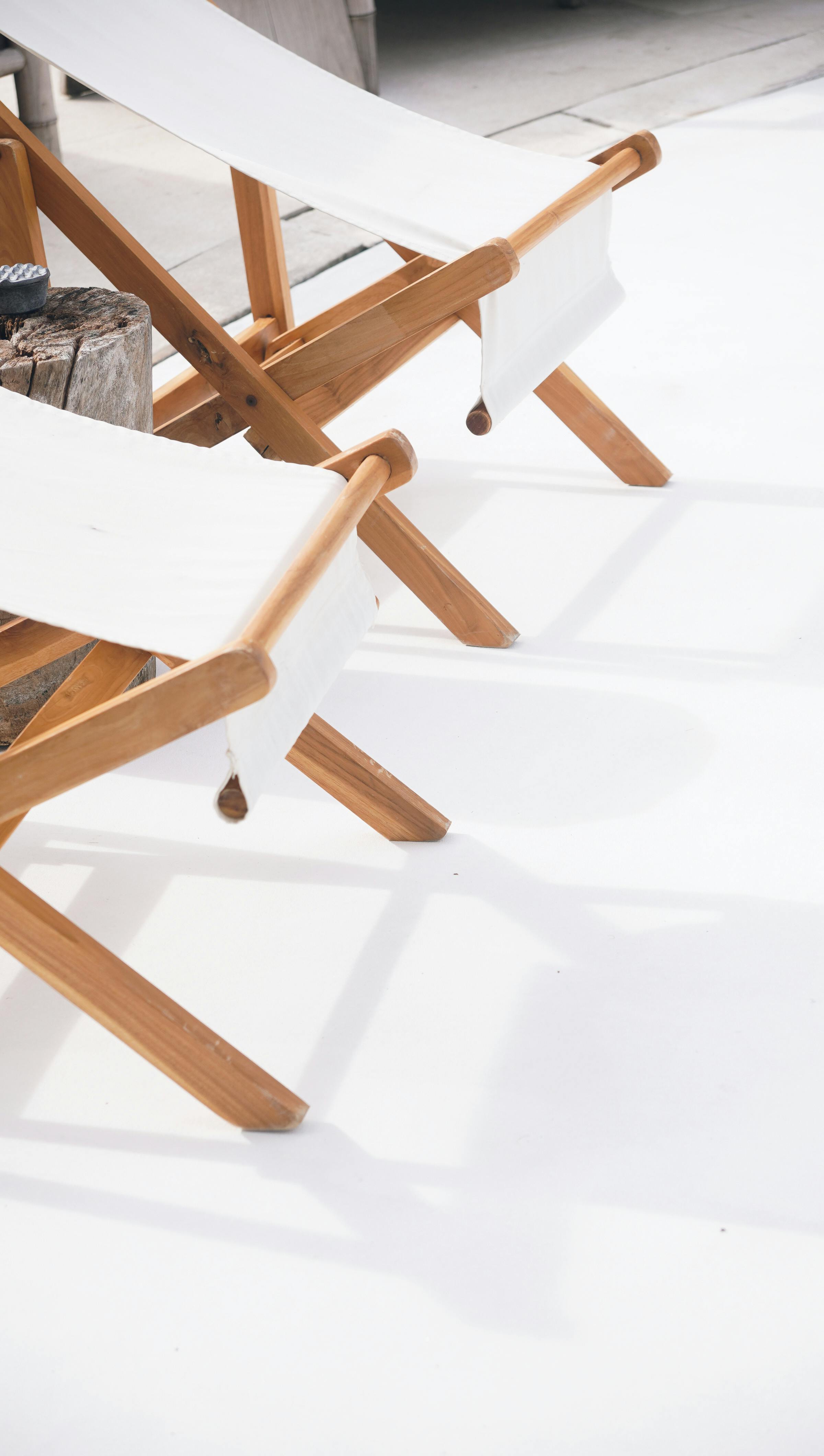 Free White canvas chairs on a sunlit patio, creating a minimalist summer setting. Stock Photo