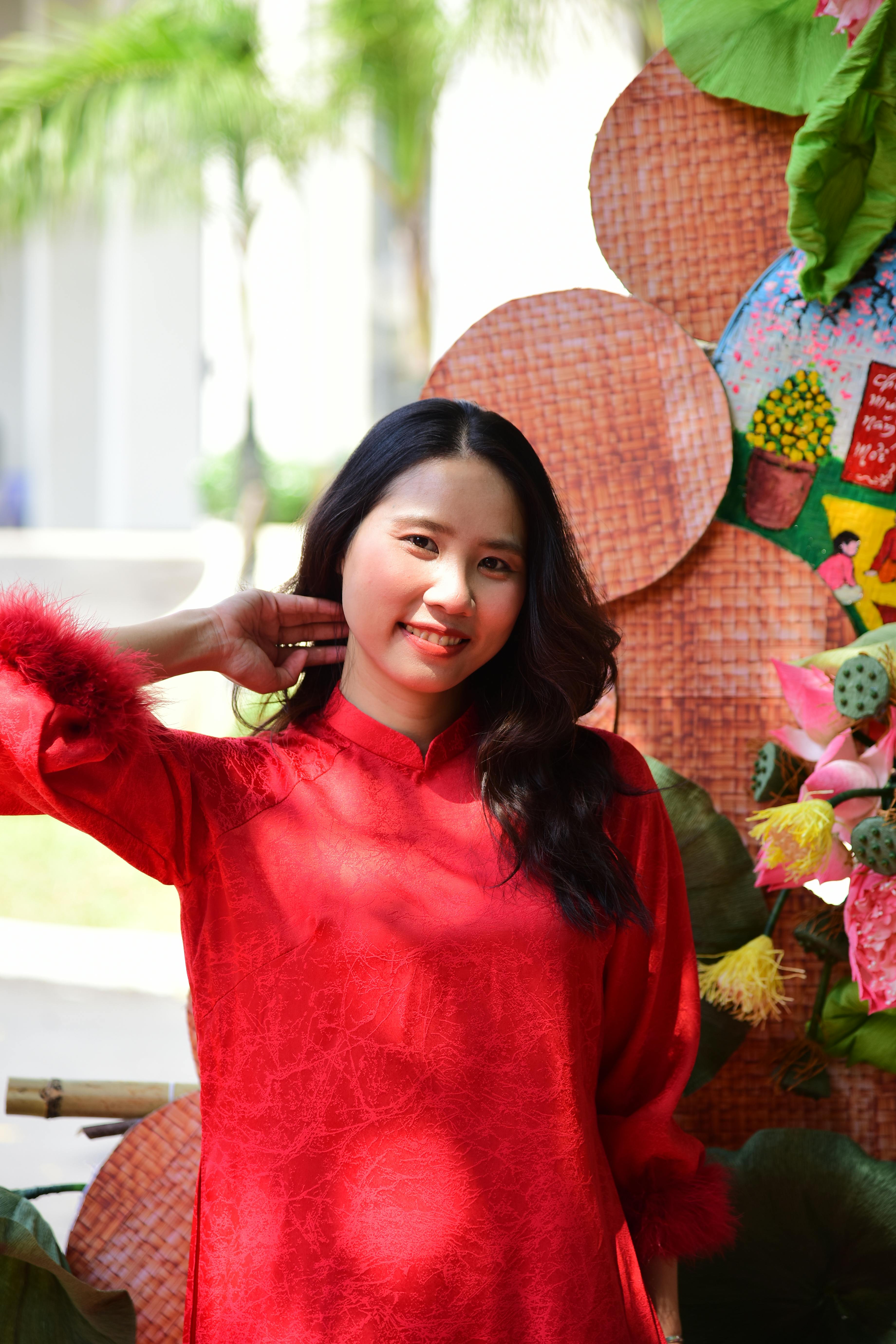 Gratis Donna in un vivace abito rosso in posa all'aperto con sfondo decorativo, che cattura l'essenza culturale. Foto a disposizione