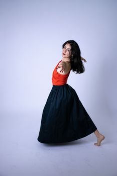 Graceful dancer in vibrant attire showcasing fluid movement in a minimalist setting.