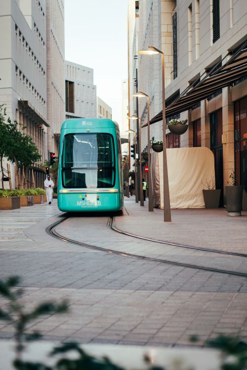 Free A sleek tram navigates through the modern streets of downtown Doha, Qatar, capturing urban transportation. Stock Photo