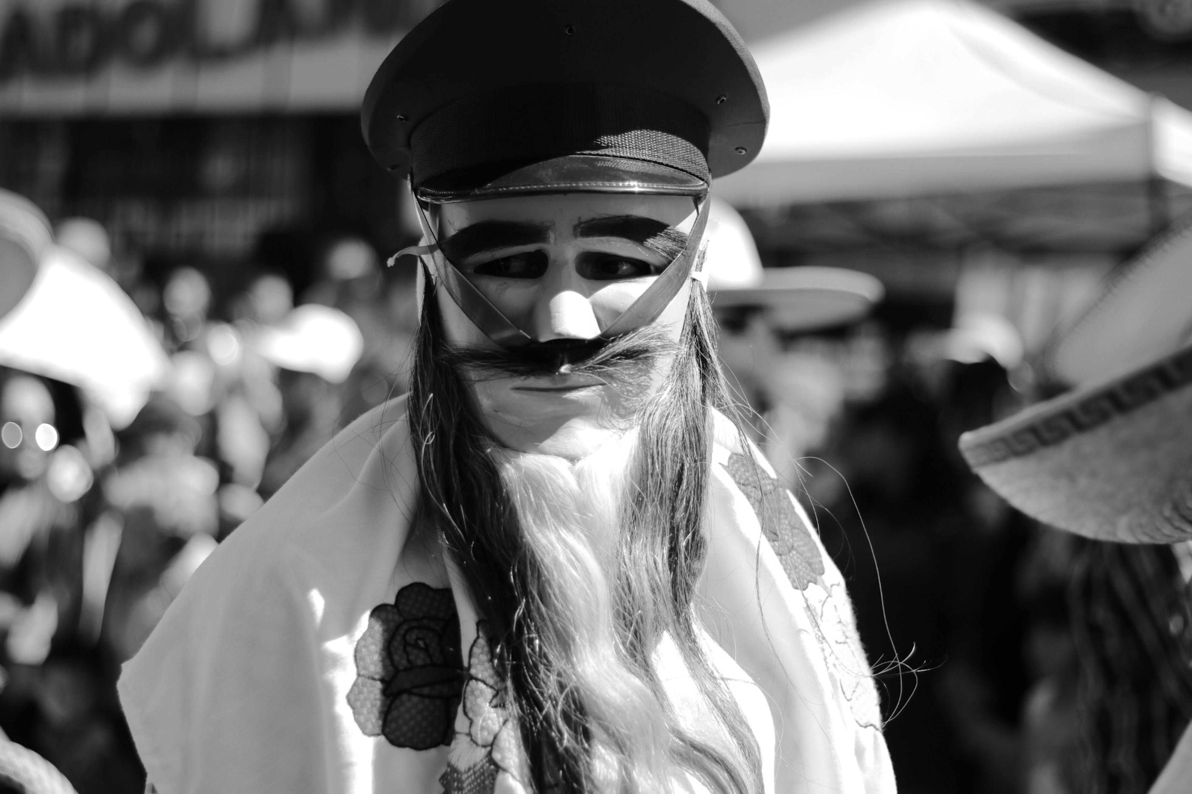 Free Black and white photo of a traditional masked participant at a parade in Pachuca, Mexico. Stock Photo