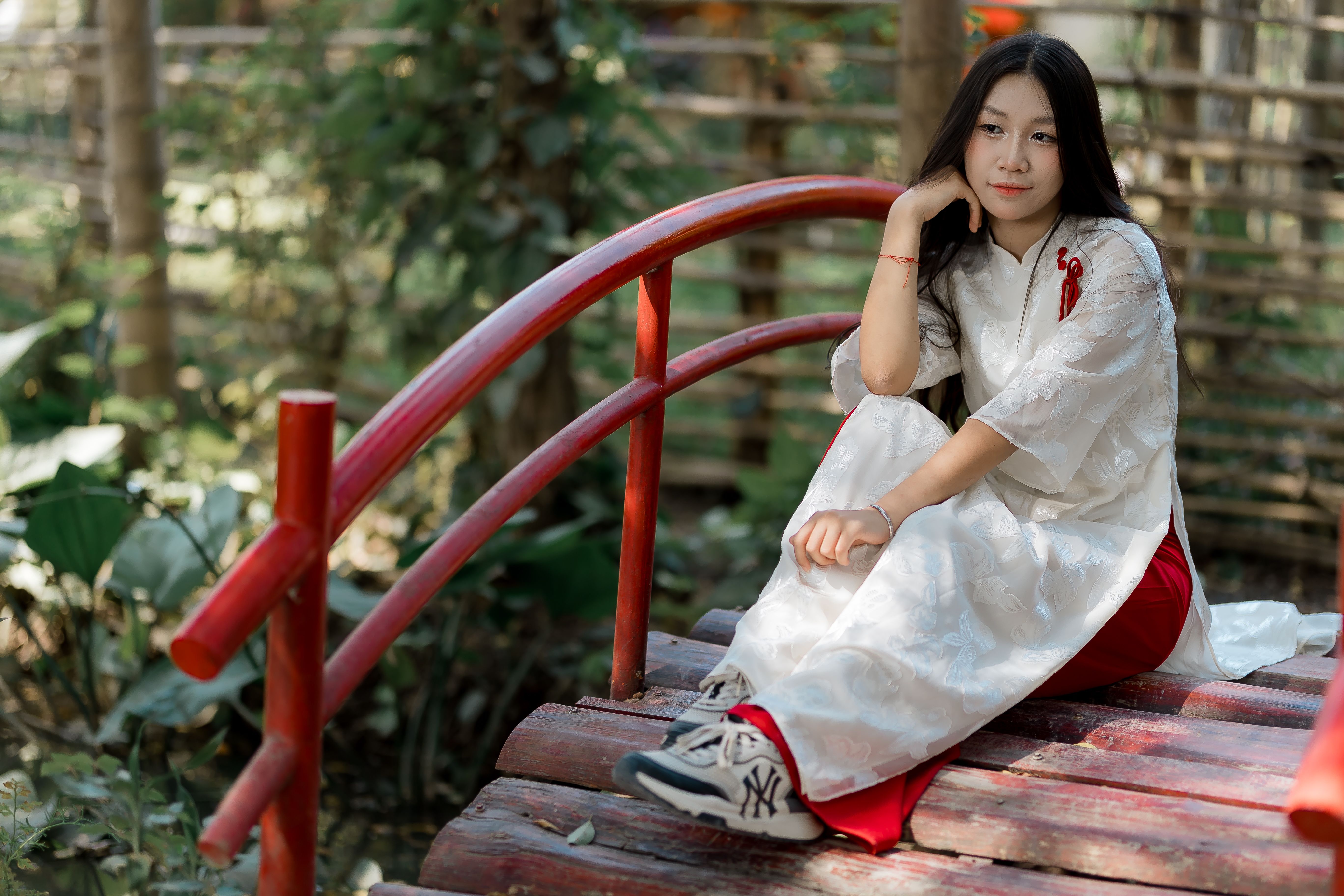 Young Woman in Traditional Dress on Wooden Bridge · Free Stock Photo