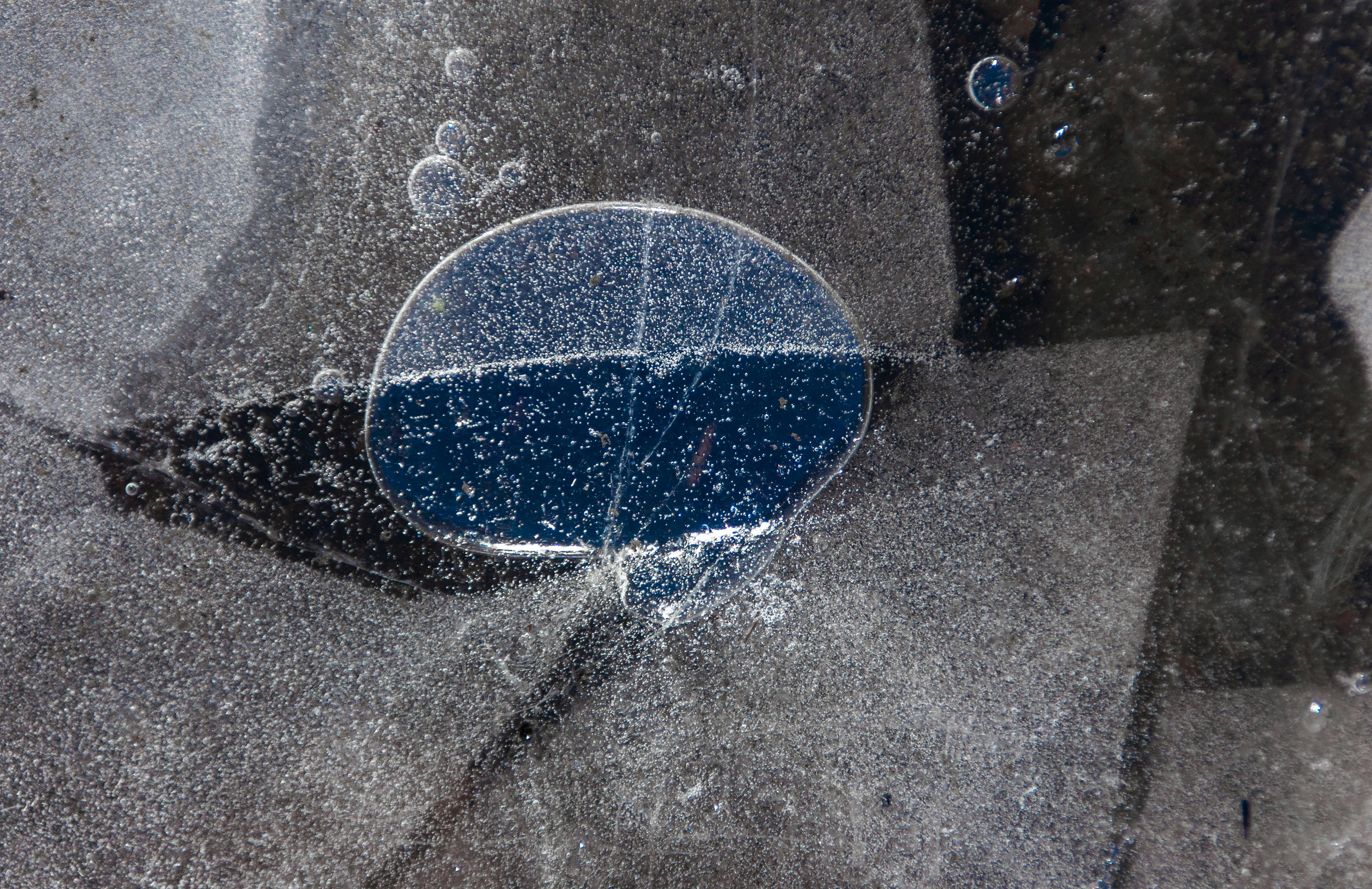 Free Close-up of a frozen surface with a trapped air bubble, creating an abstract pattern. Stock Photo