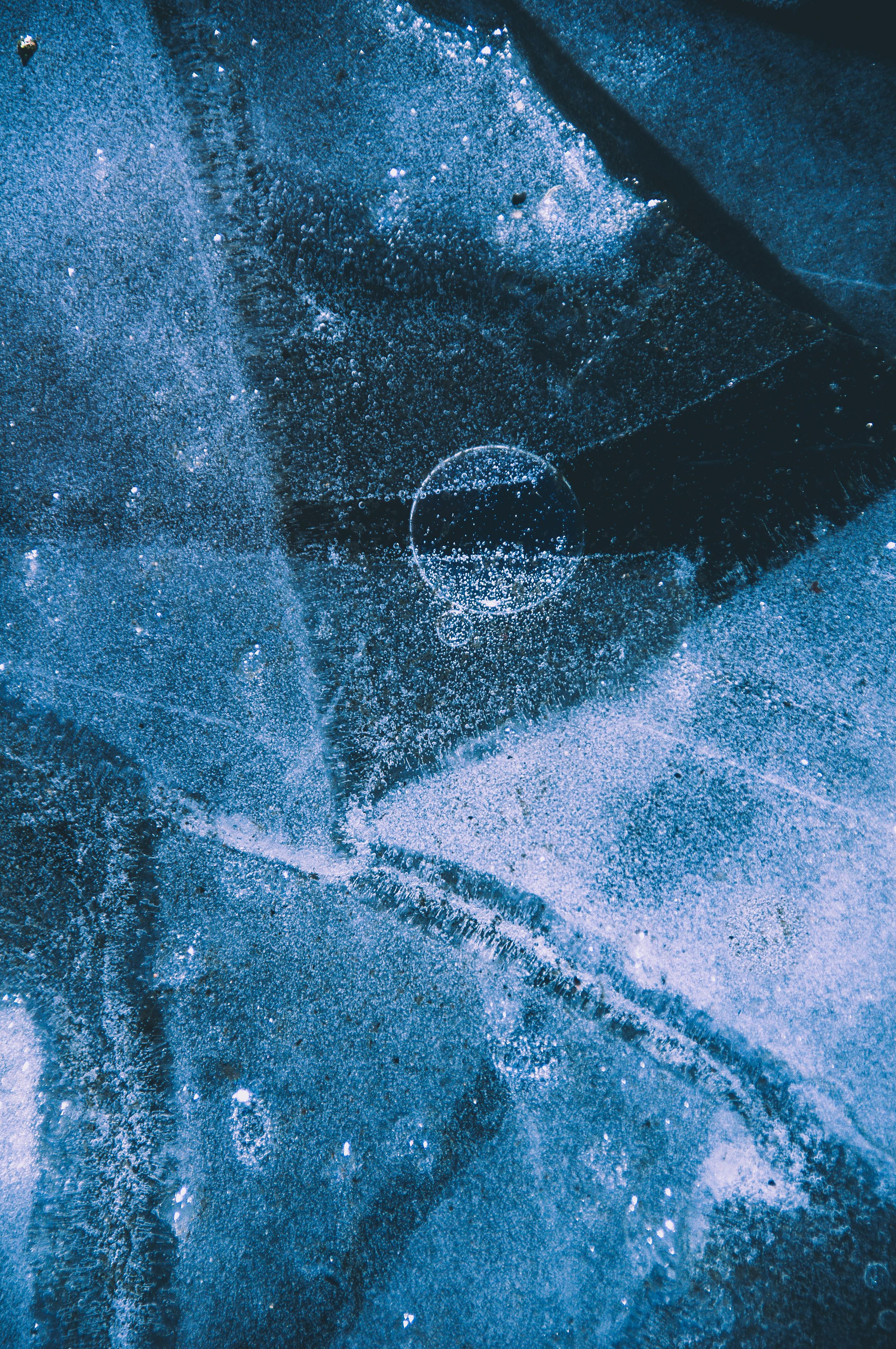 Free Close-up of intricate frost patterns on a textured icy surface with a cool blue tone. Stock Photo
