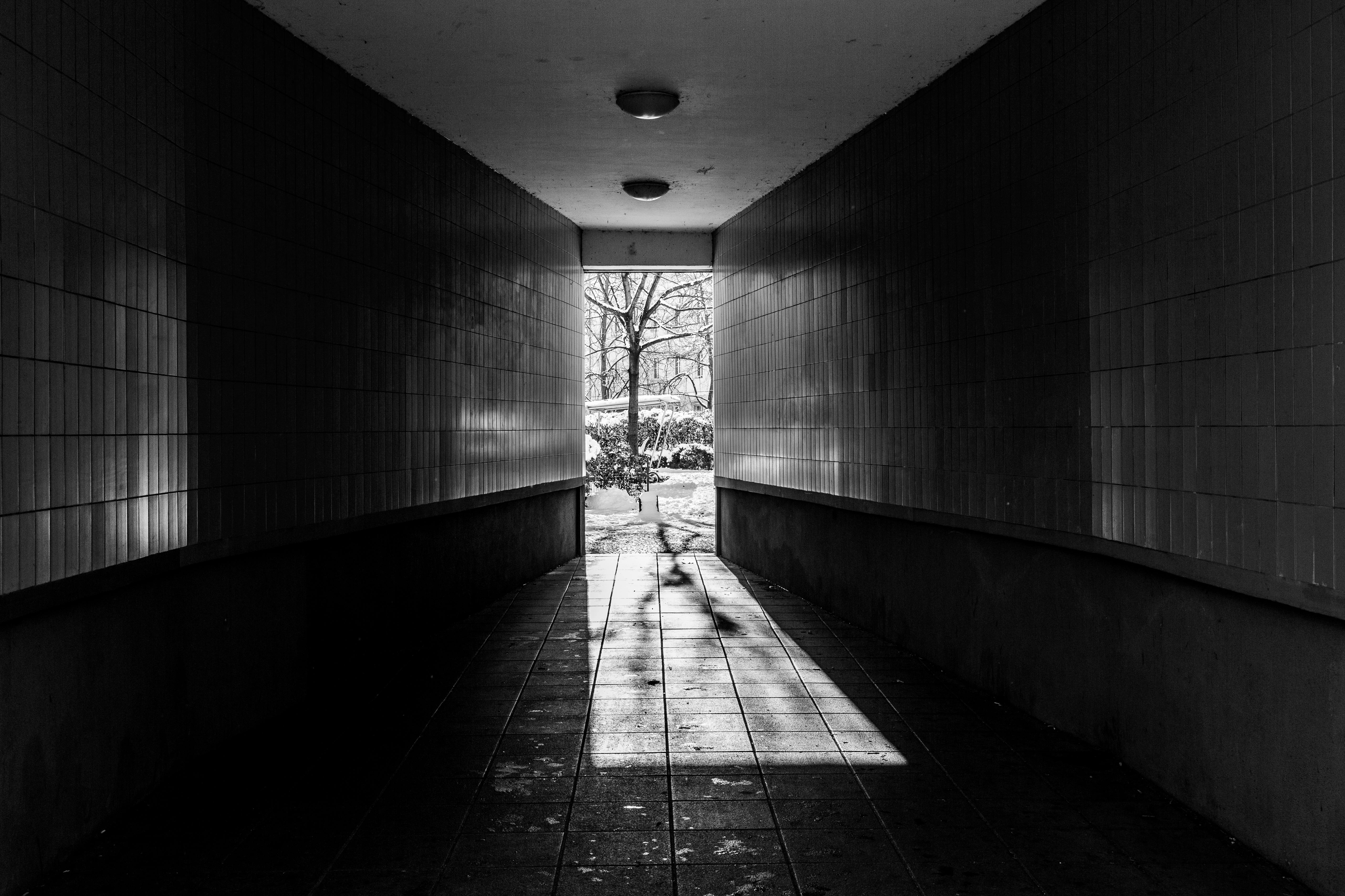 Gratis Et dramatisk svart-hvitt-bilde av en urban tunnel som fører mot lys. Arkivbilde