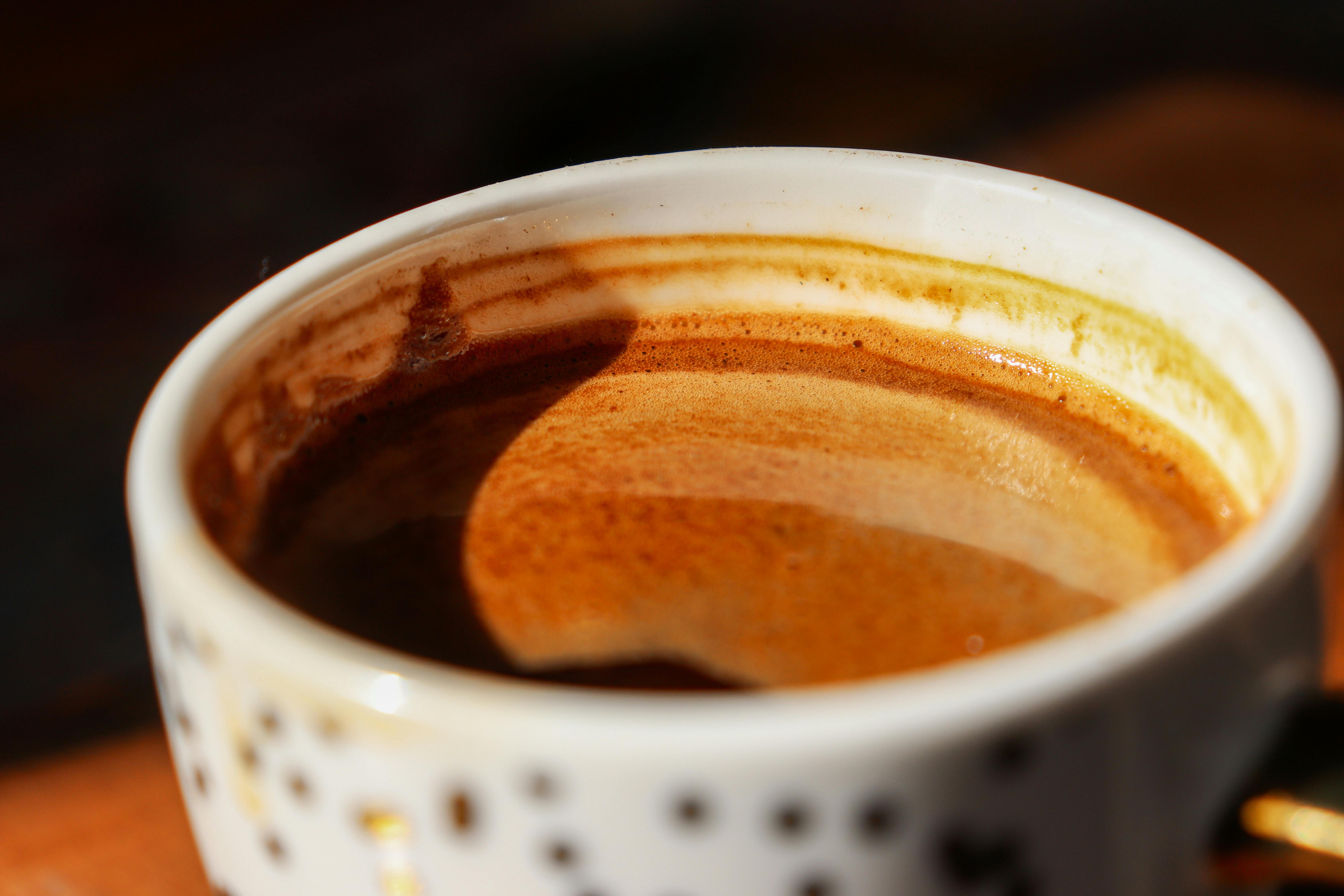 ฟรี ภาพระยะใกล้ที่อบอุ่นและน่ารับประทานของกาแฟเอสเปรสโซในถ้วยลายสวยพร้อมครีมฟองหนานุ่ม คลังภาพถ่าย