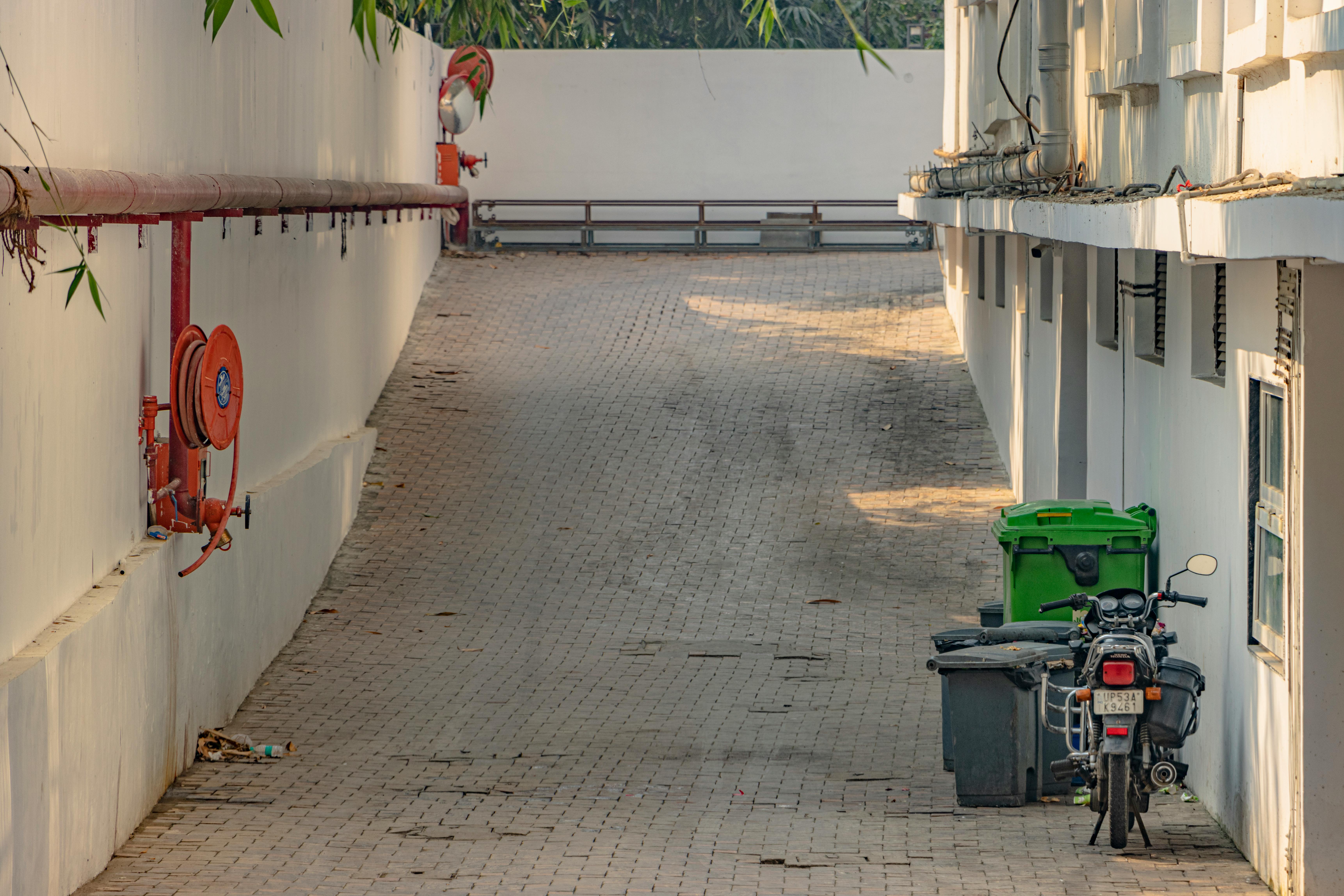 gratis Rustig stadssteegje in Maharajganj, Uttar Pradesh, met een motorfiets en brandveiligheidsapparatuur. Stockfoto