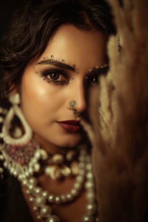 Free Close-up portrait of a woman with intricate traditional jewelry and makeup showcasing cultural elegance. Stock Photo